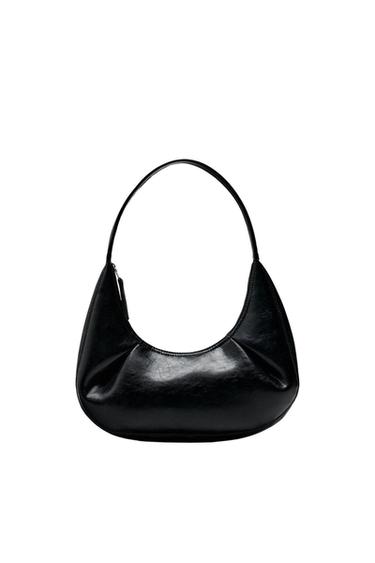 Front view of a black bag with a top handle and a curved design.
