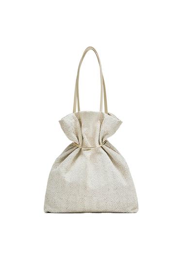 Textured beige tote bag with long handles and a ruched design at the top, on a white background.