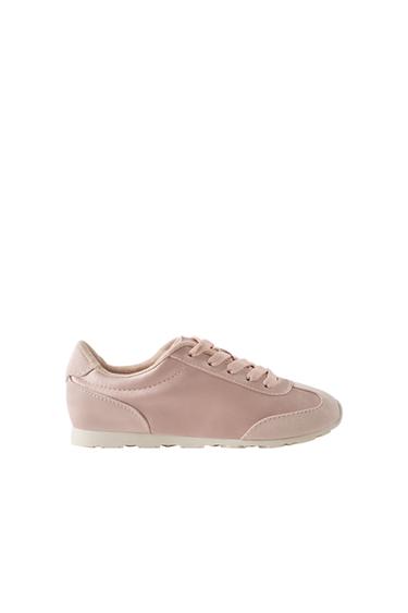 Side view of pink trainer with laces and white sole.