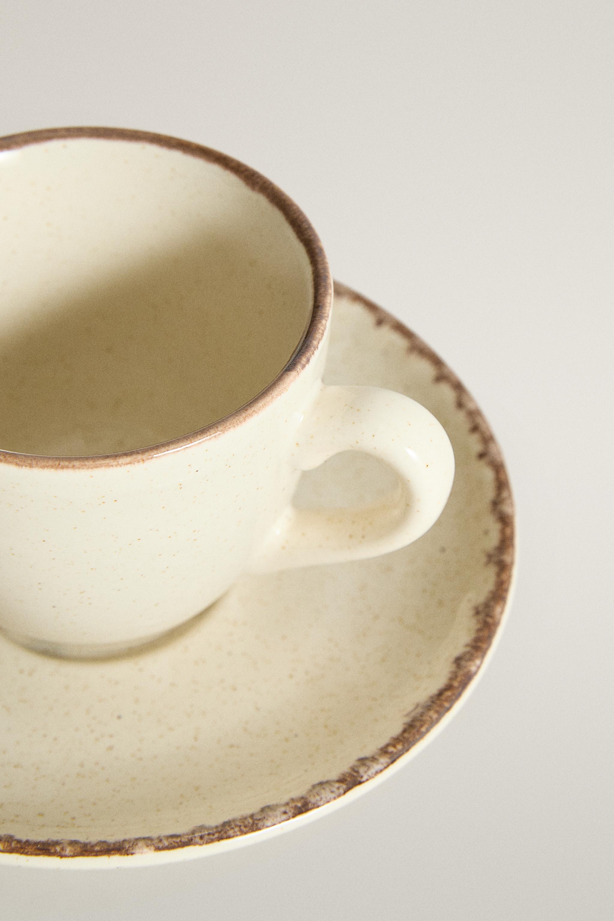 STONEWARE COFFEE CUP AND SAUCER WITH DISTRESSED RIM