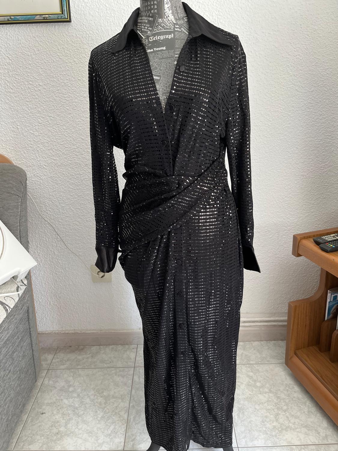 Mannequin in a room with a sofa, wearing a black sequinned shirt dress with a knot detail. Text: Telegraph, the Young, I love.