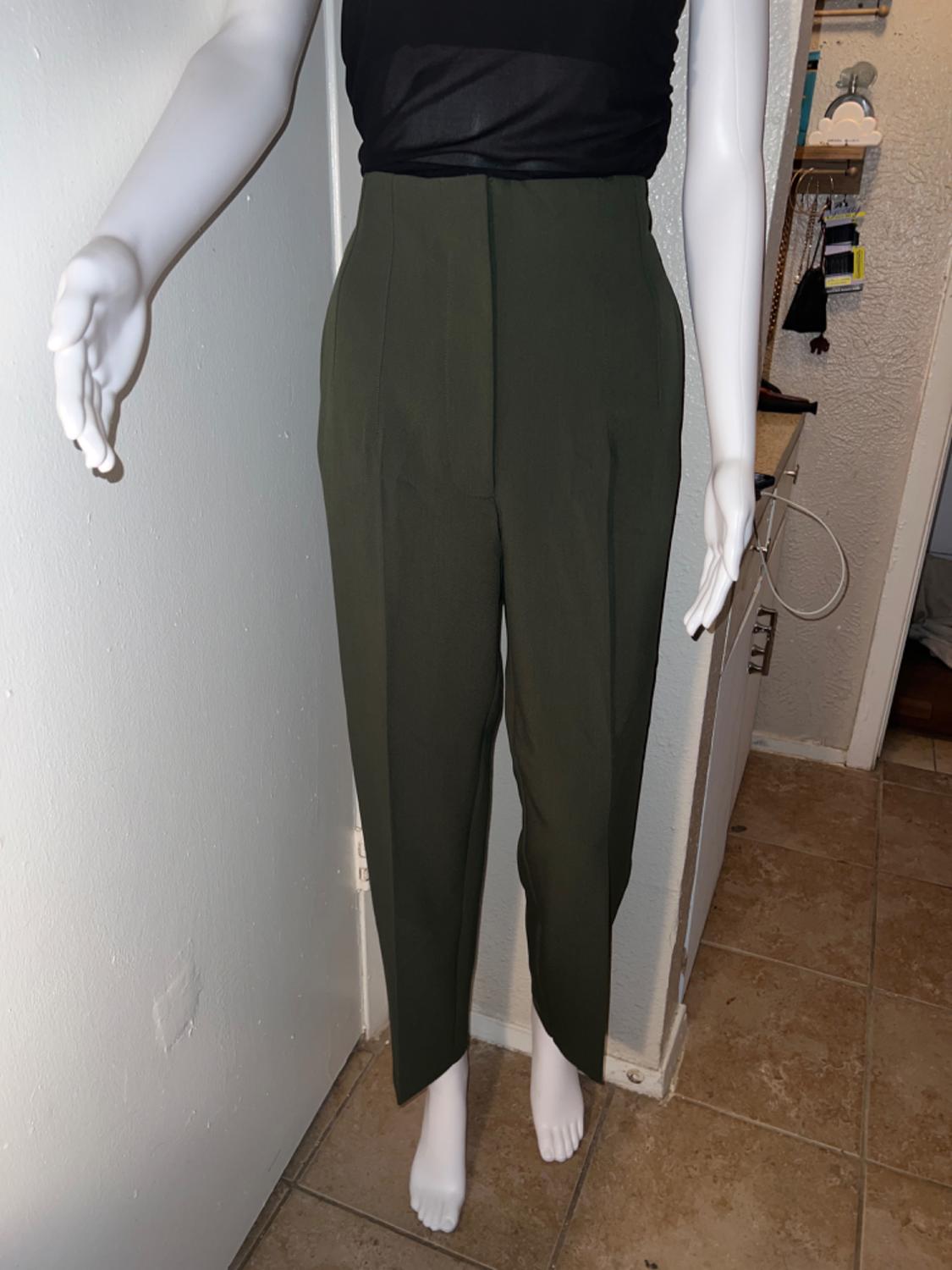 Olive green high-waisted trousers with front pleats, front view on a mannequin.