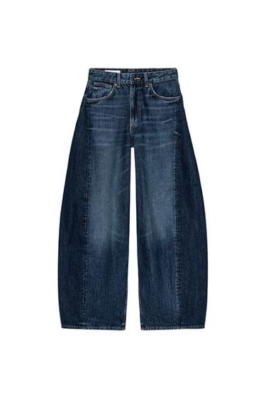 Front view of navy blue oversized jeans, mid-rise, five pockets, twisted seams, zip and button fastening.