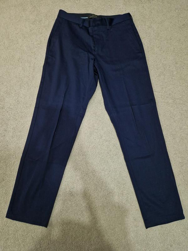 Front view of navy blue trousers with side pockets.