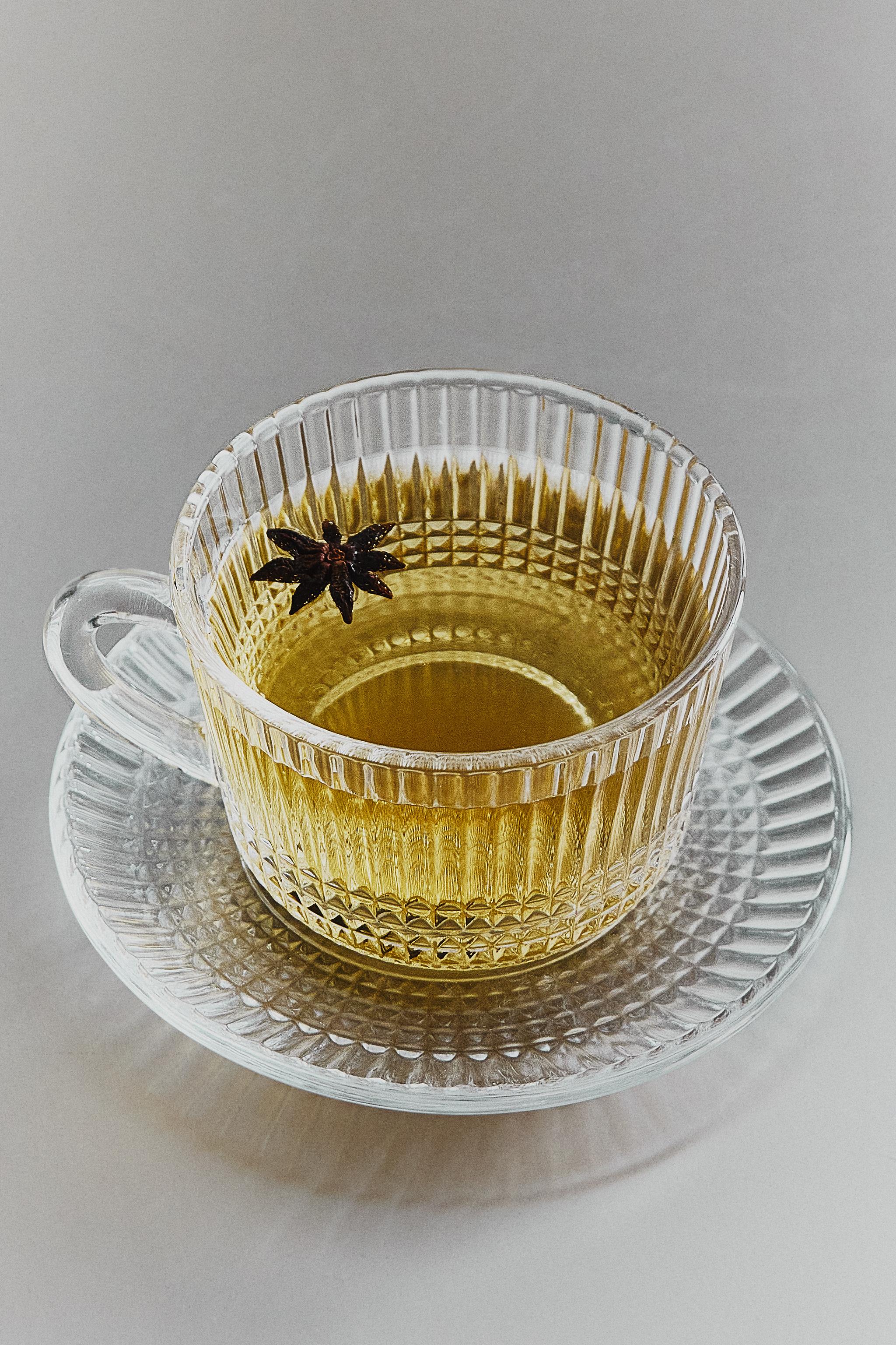 GLASS TEACUP AND SAUCER WITH GEOMETRIC RELIEF — Transparent