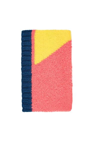 Knitted scarf with geometric design in blue, yellow, and pink colours on a white background.