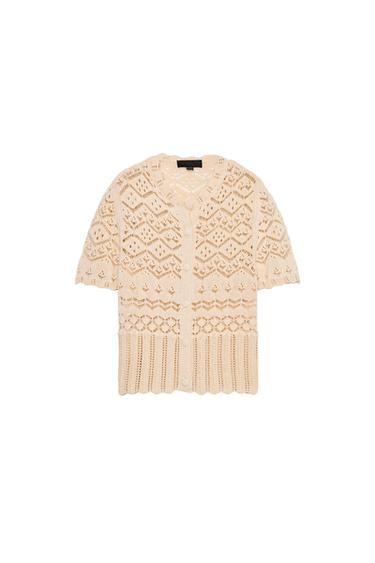 Front view of a beige cardigan with a lace-up design and buttons.