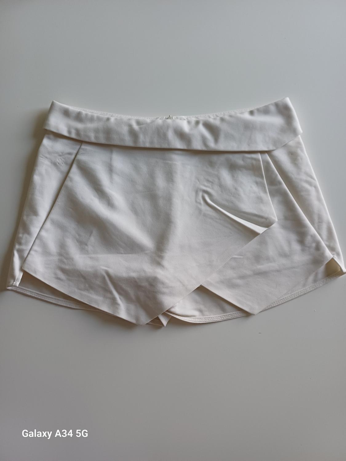 Front view of a white short skirt with pleats and a wide waistband.
