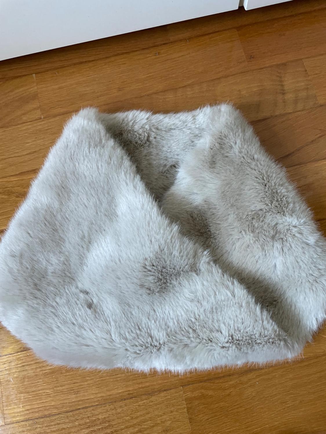 Detail of a light grey scarf with a furry texture.