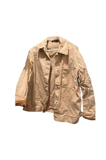 Front view of a beige jacket with a side pocket and visible buttons.