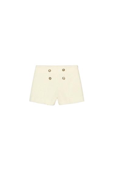 Front view of white shorts with button-up fastening.