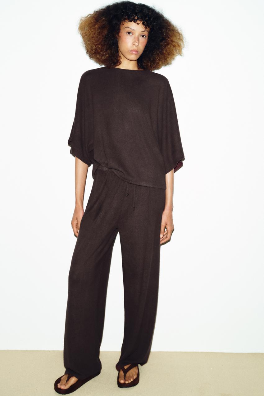 Brown short-sleeved blouse and brown wide-leg pants set with an elastic waist.