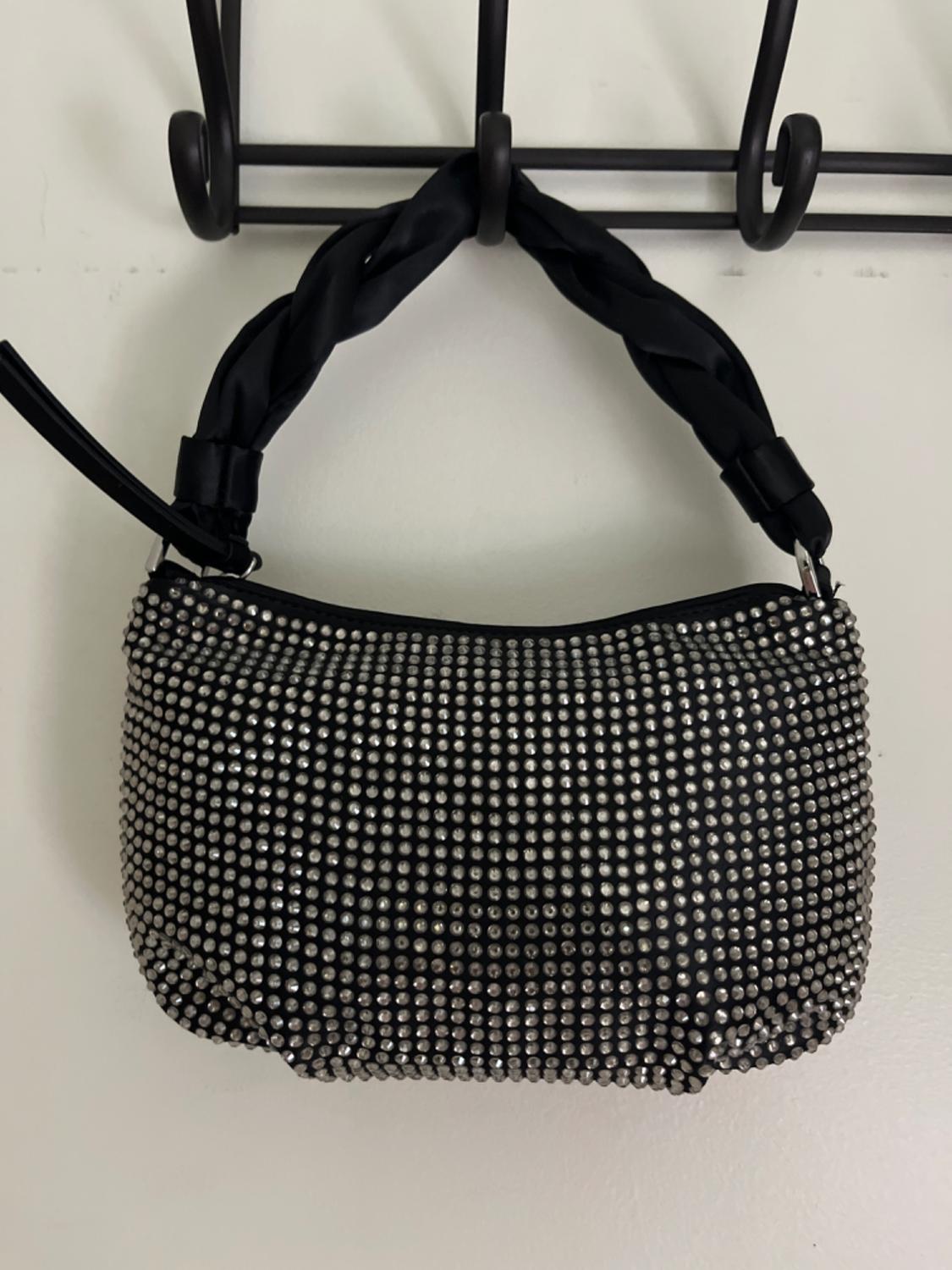 Small black bag with silver studs and a braided handle.