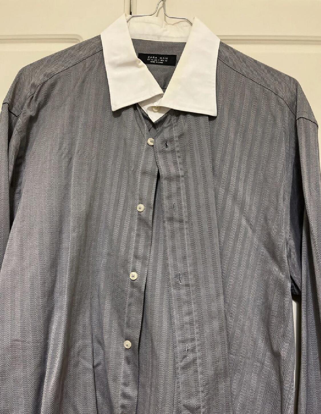 Front view of a grey shirt with a white collar and front buttons.