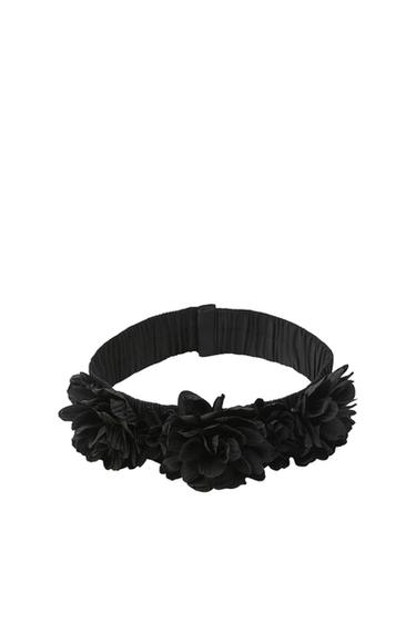 Black belt with decorative flowers along its entire length.