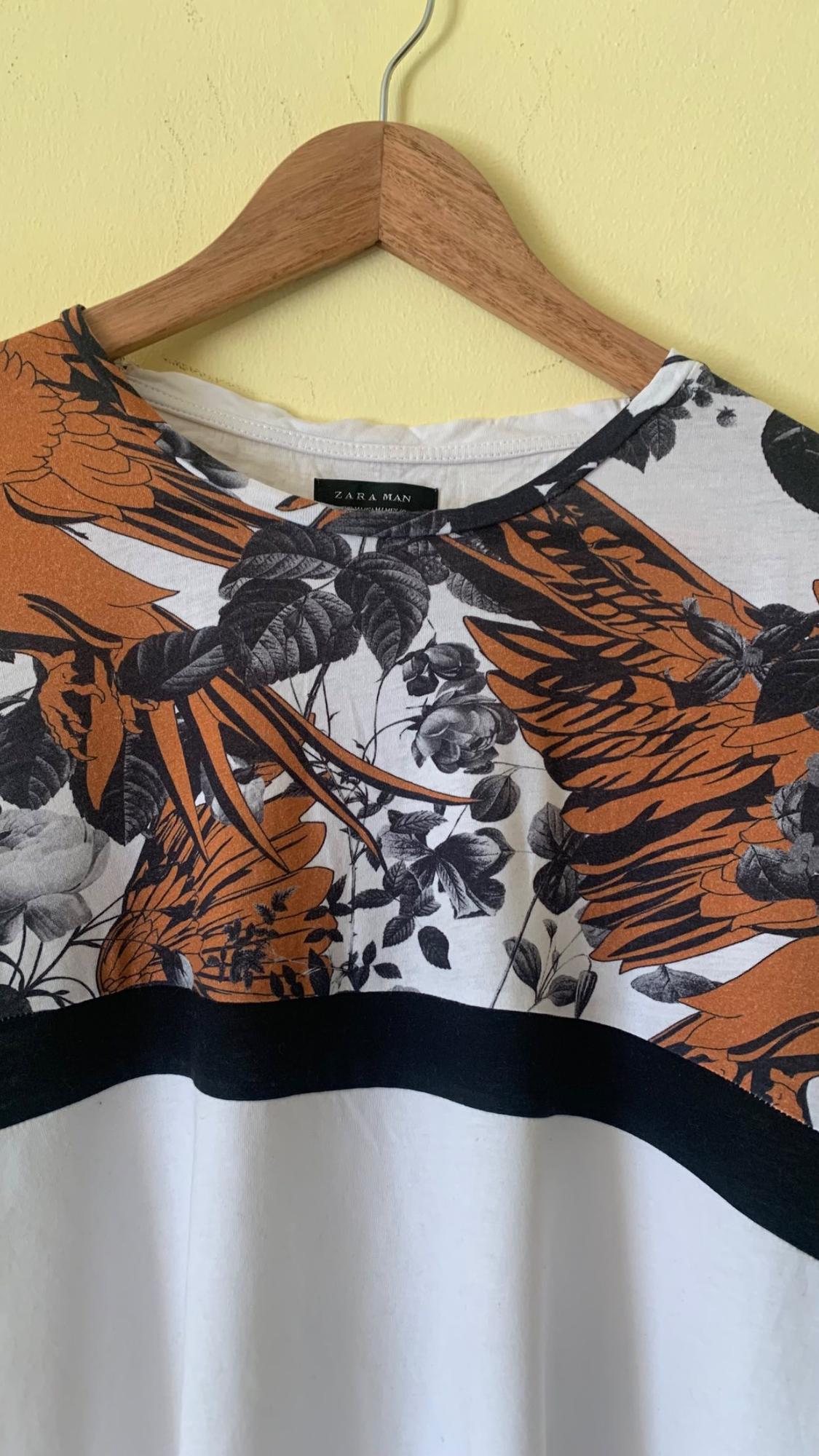 T-shirt neck detail with black and orange floral print and 'ZARA MAN' text.
