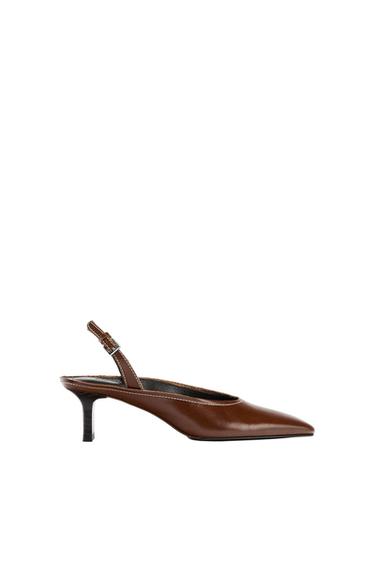 Brown low-heel shoe with a pointed toe and adjustable strap, on a white background.