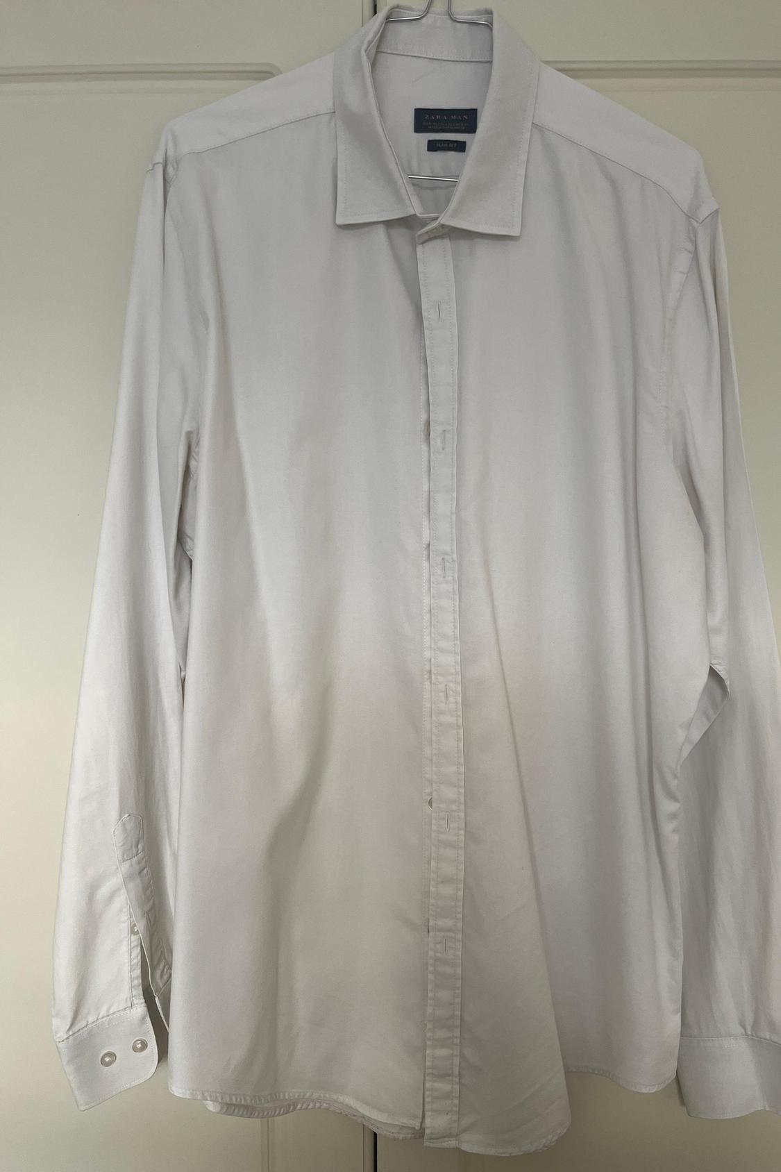 Front view of a white shirt with a classic collar and central button placket.