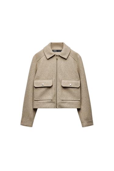 Front view of a beige jacket with zip fastening and front flap pockets.