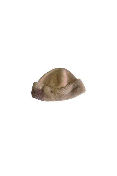 Beige faux fur hat with a turned-up brim, on a white background.