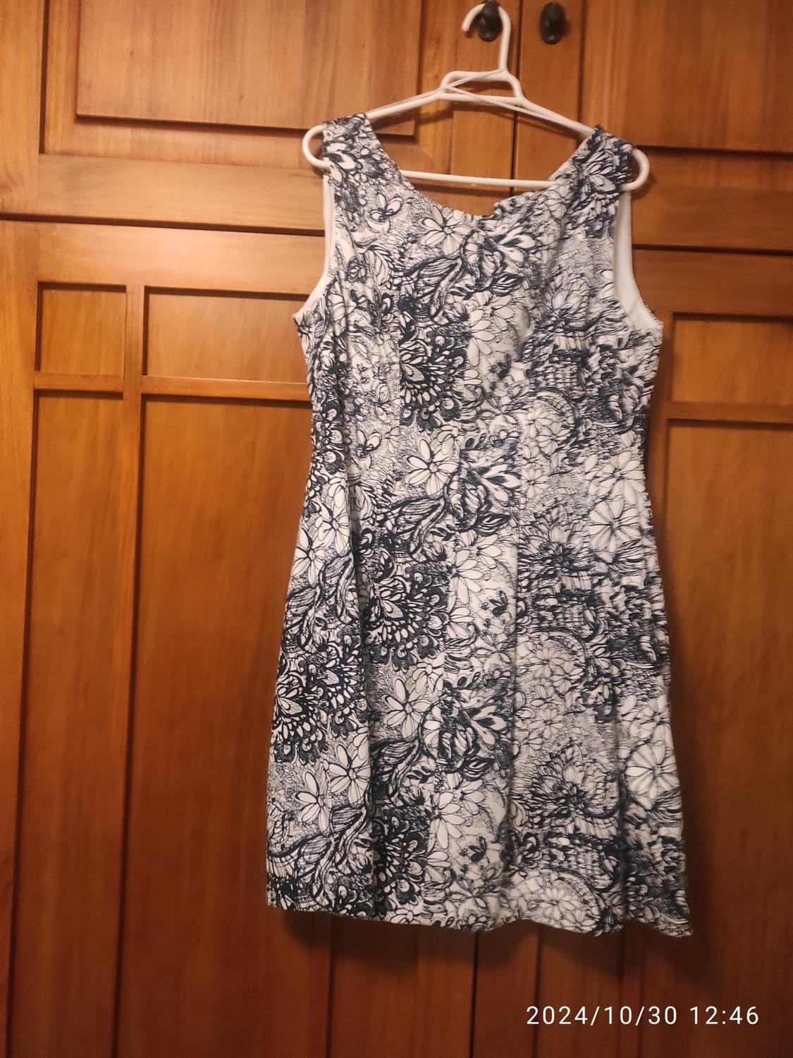 Front view of a sleeveless dress with a black and white floral print.