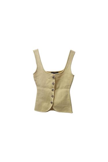 Pale yellow structured sleeveless top with a square neckline and front button fastening against a white background.