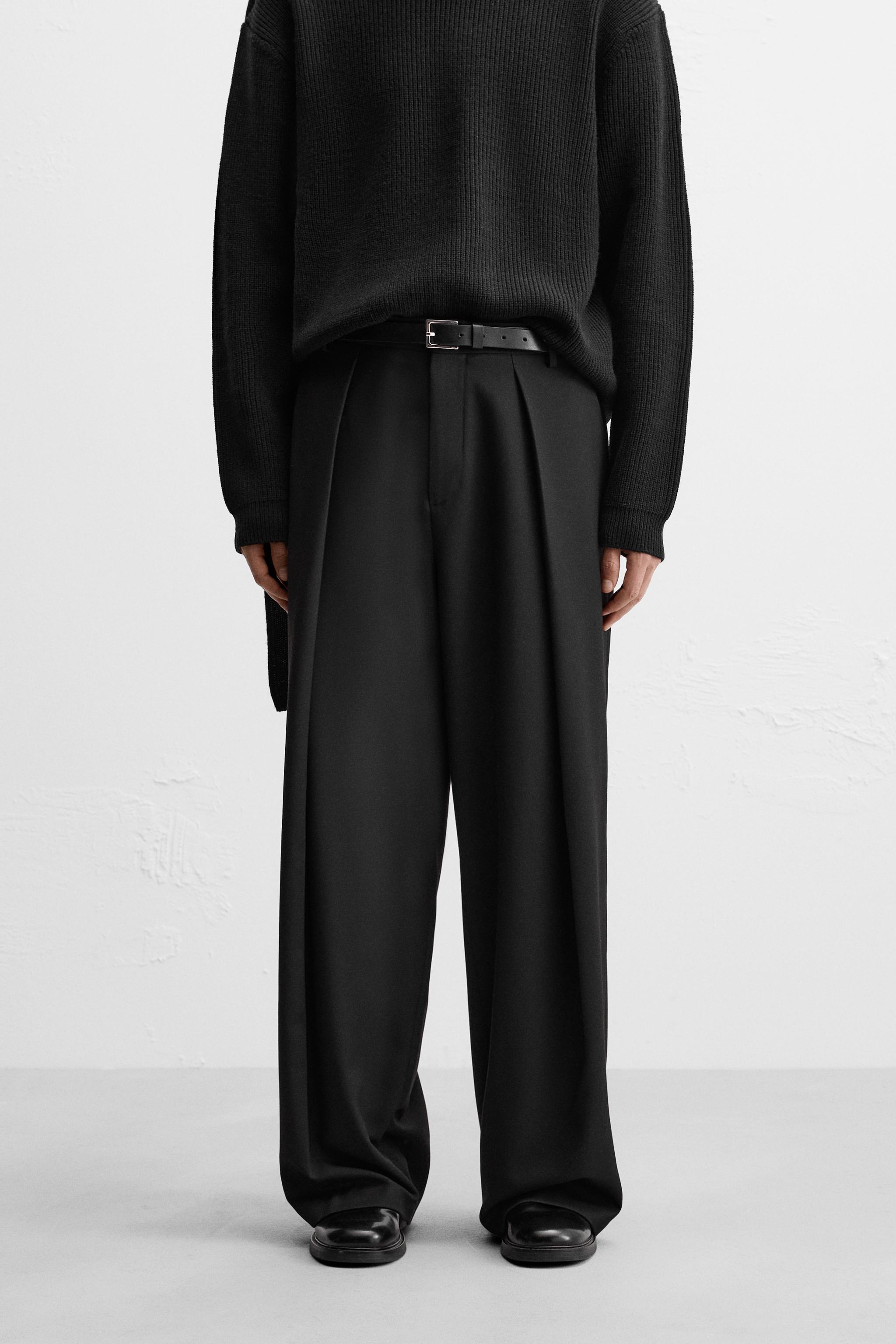 Wide fit pants. Front pleats at waist. Side pockets and back welt pockets.  Front zip and hidden metal hook closure.