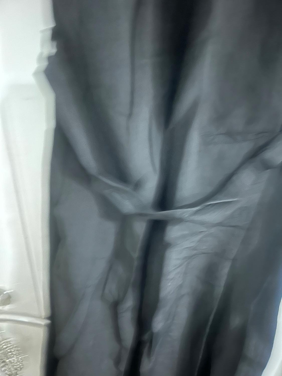 Wrinkled grey fabric hanging, with a white background. The image has a soft focus and a relaxed atmosphere.