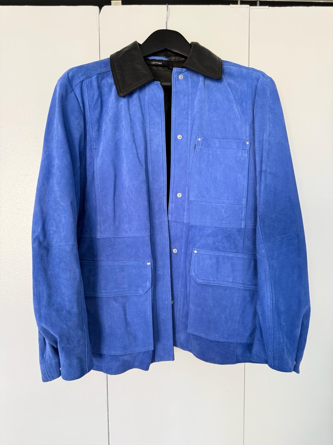 Blue jacket with a black collar and pockets, hanging on a hanger in front of white doors. Interior label with the text LEATHER.