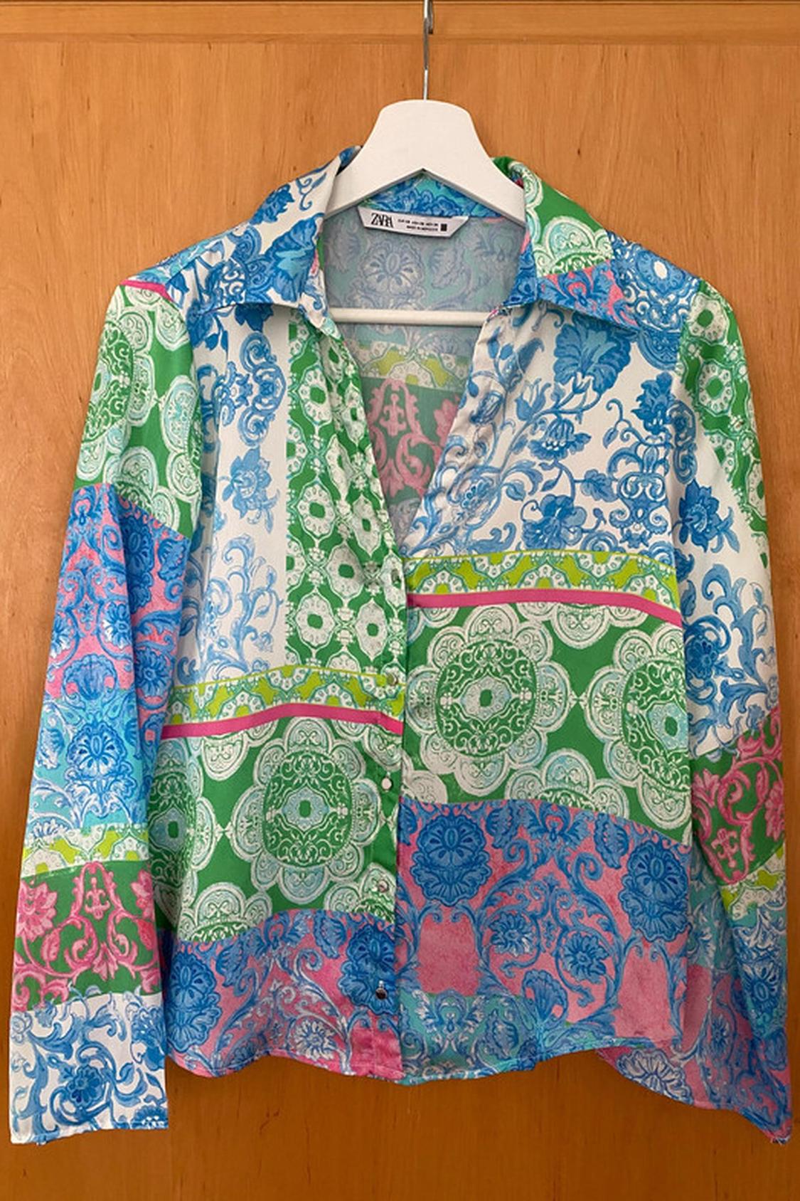 Front view of a multi-coloured print shirt in green, blue and pink, with a classic collar and button-through front.