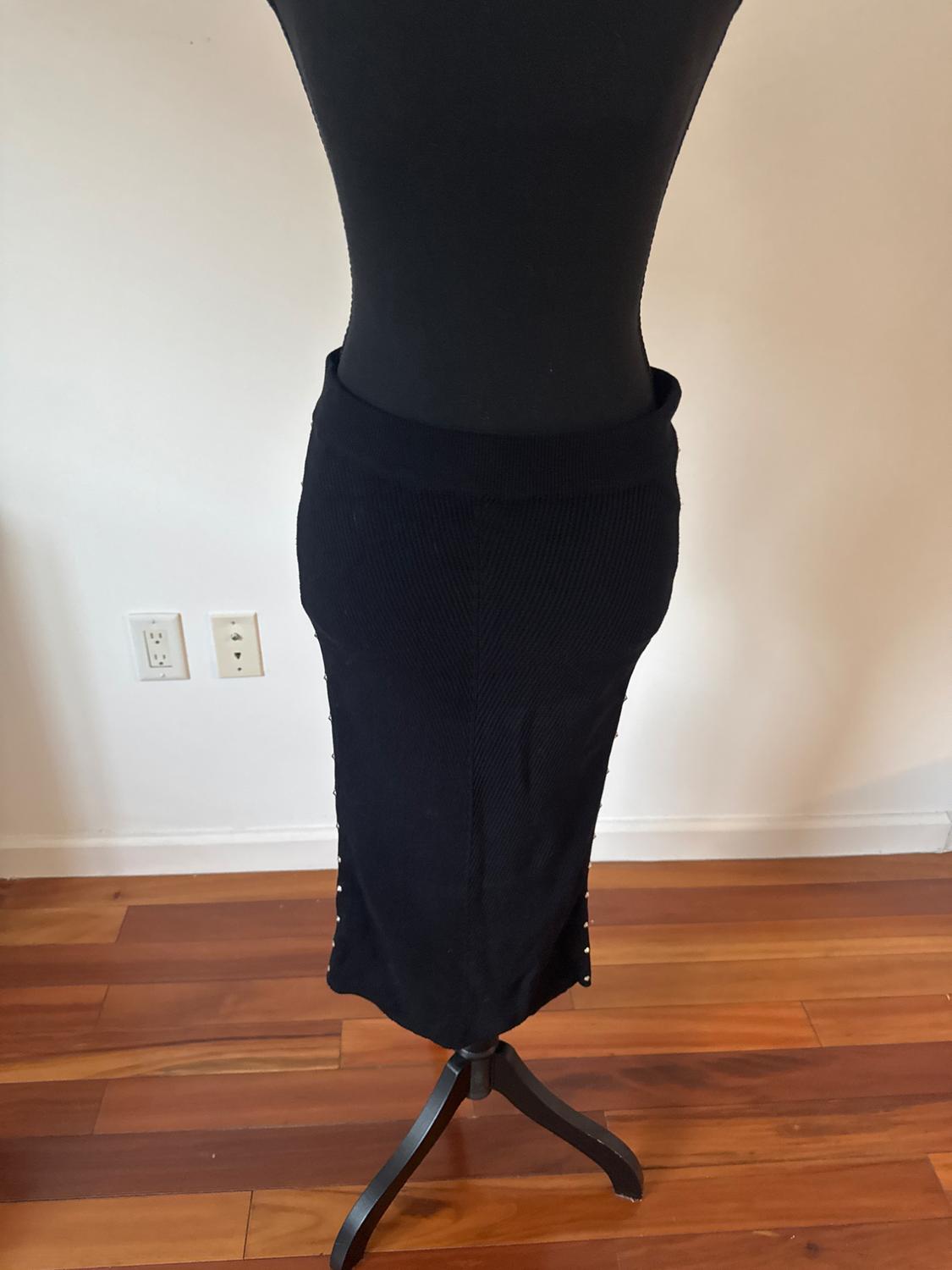 Fitted black skirt with visible side buttons.