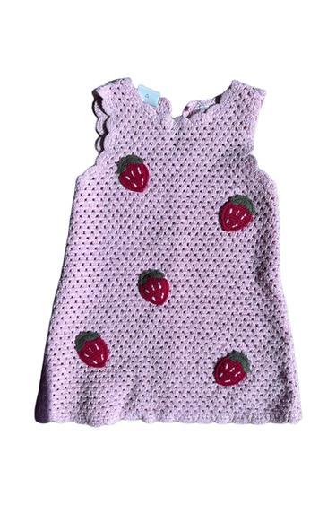 Light pink crochet sleeveless dress with appliqués of red strawberries and green leaves, on a white background.
