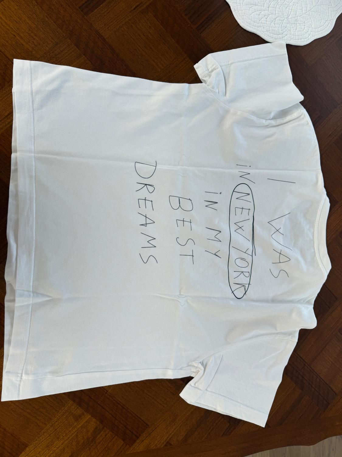 Λευκό t-shirt απλωμένο σε ξύλινο πάτωμα με το κείμενο I WAS IN NEW YORK IN MY BEST DREAMS.