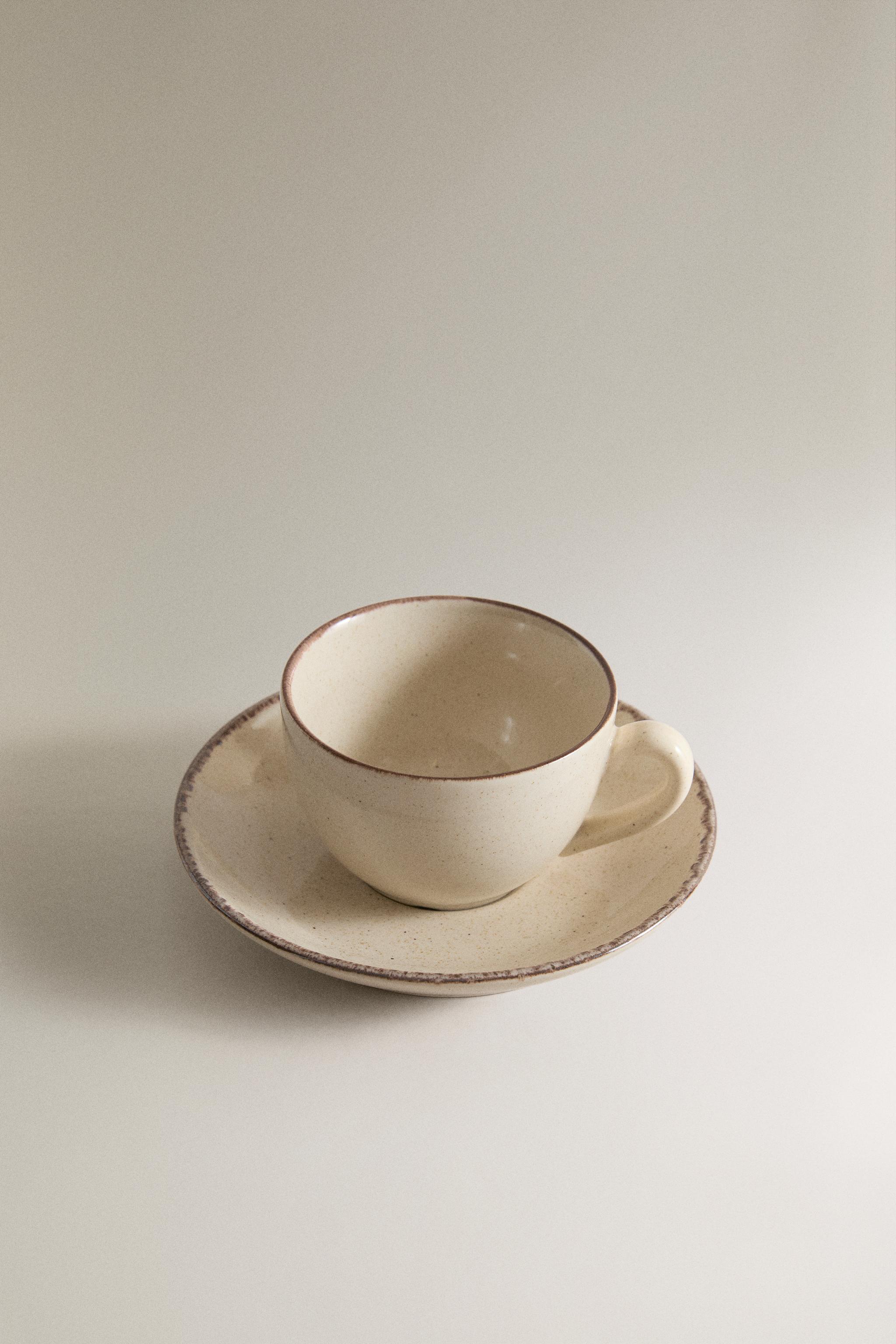 STONEWARE TEACUP AND SAUCER WITH DISTRESSED RIM — Light ecru