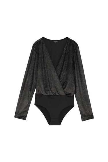 Long-sleeved black bodysuit with shimmer and a crossover neckline. White background. Visible tag on the neck.