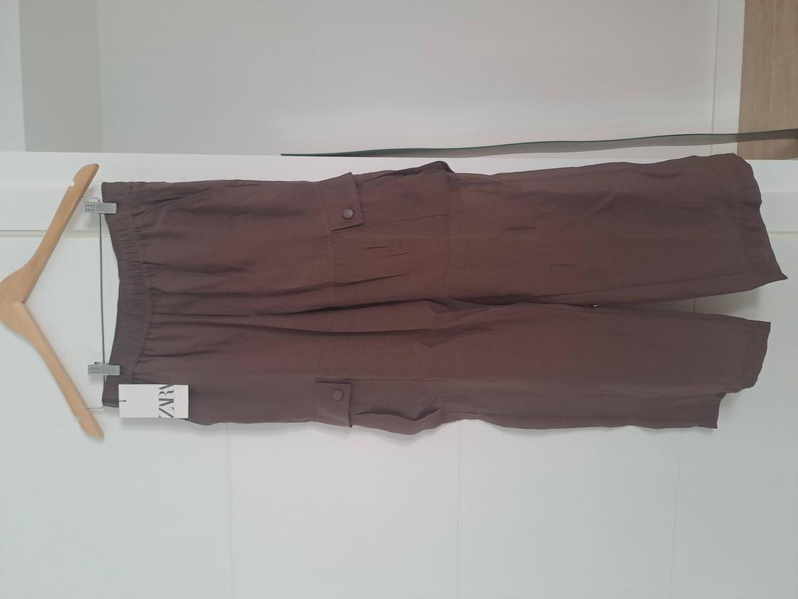 Casual brown cargo trousers with an elasticated waist and pockets, hanging on a wooden hanger against a white background. ZAR label.