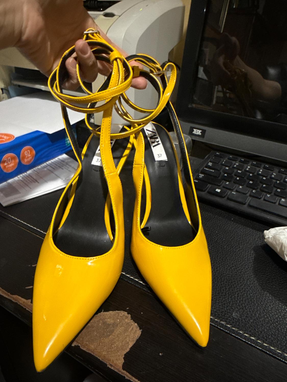 Yellow heeled shoes with long straps, front view. Visible label with text 'ZARA 37'.