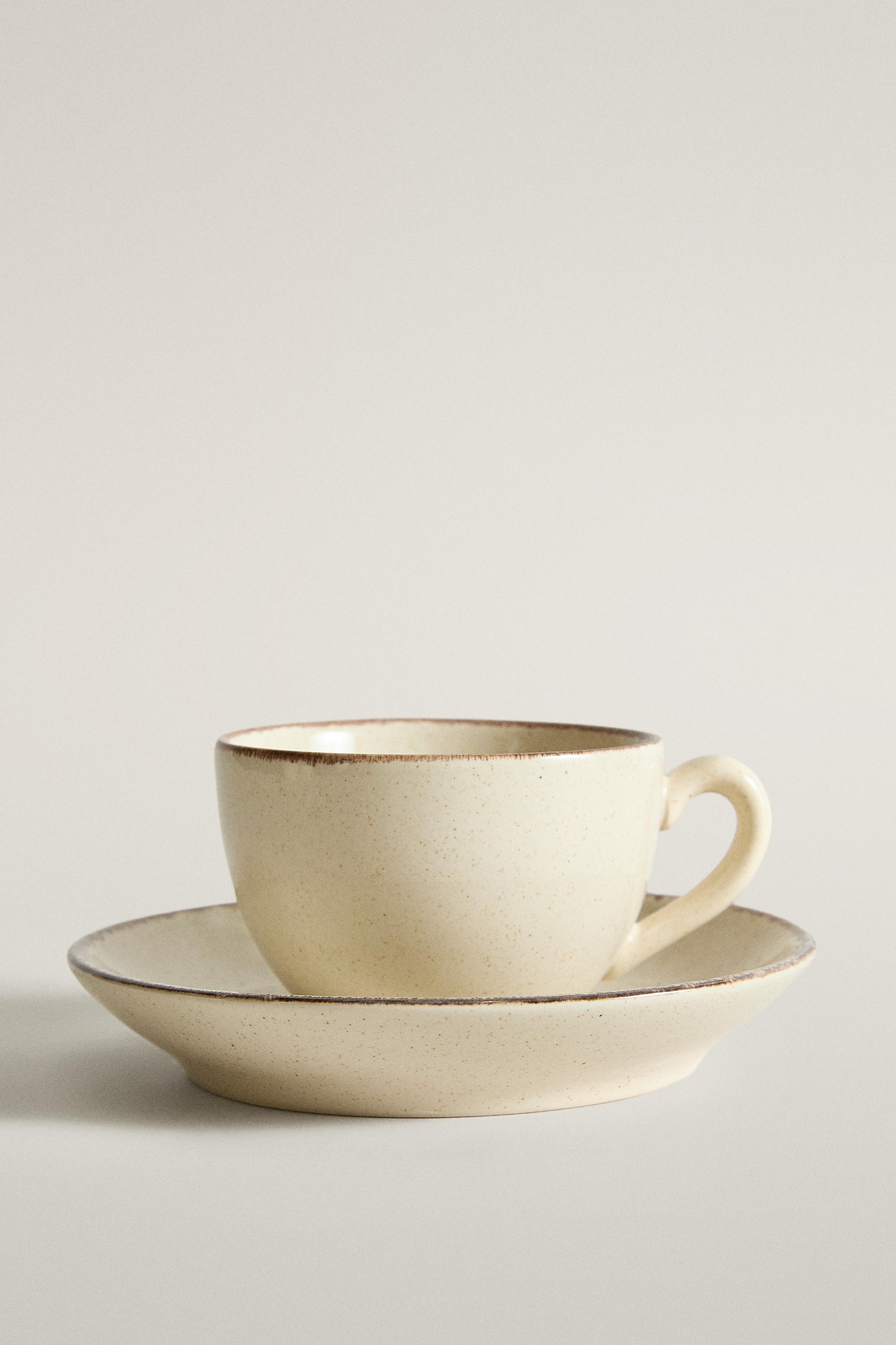 STONEWARE TEACUP AND SAUCER WITH DISTRESSED RIM