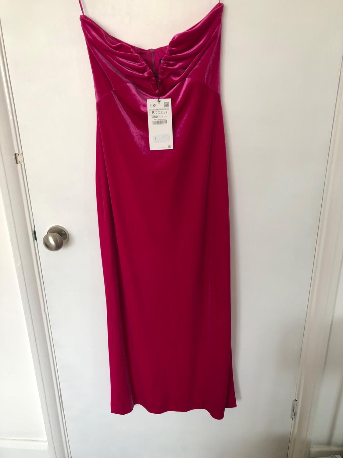 Front view of a long fuchsia dress with spaghetti straps and draping at the neckline.
