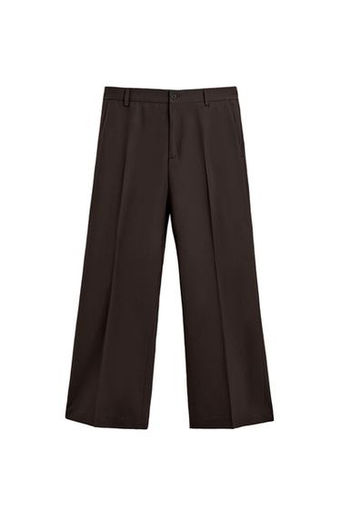 Front view of brown flare fit trousers, front pockets, double-welt back pockets, zip and button fastening.