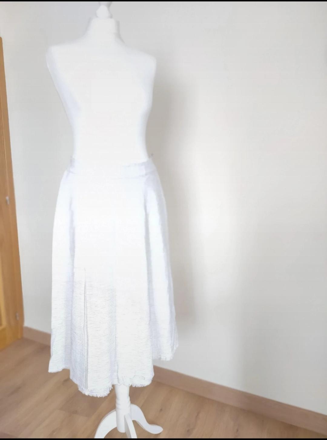 Front view of a white skirt with pleats and a wide drape.
