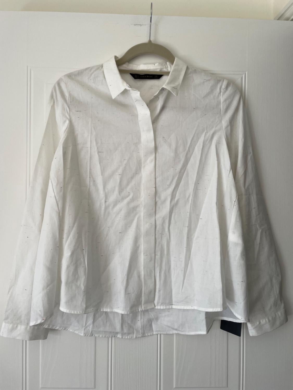 Front view of a white shirt with a classic collar and long sleeves.