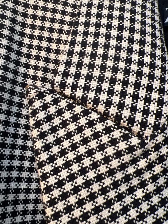 Black and white plaid fabric, showing a repetitive geometric design and woven texture.