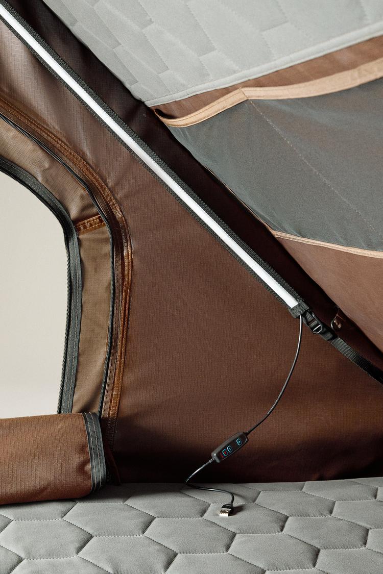 Detail of the tent interior. Shows light strip, cable with switch, USB connector and grey padded base.