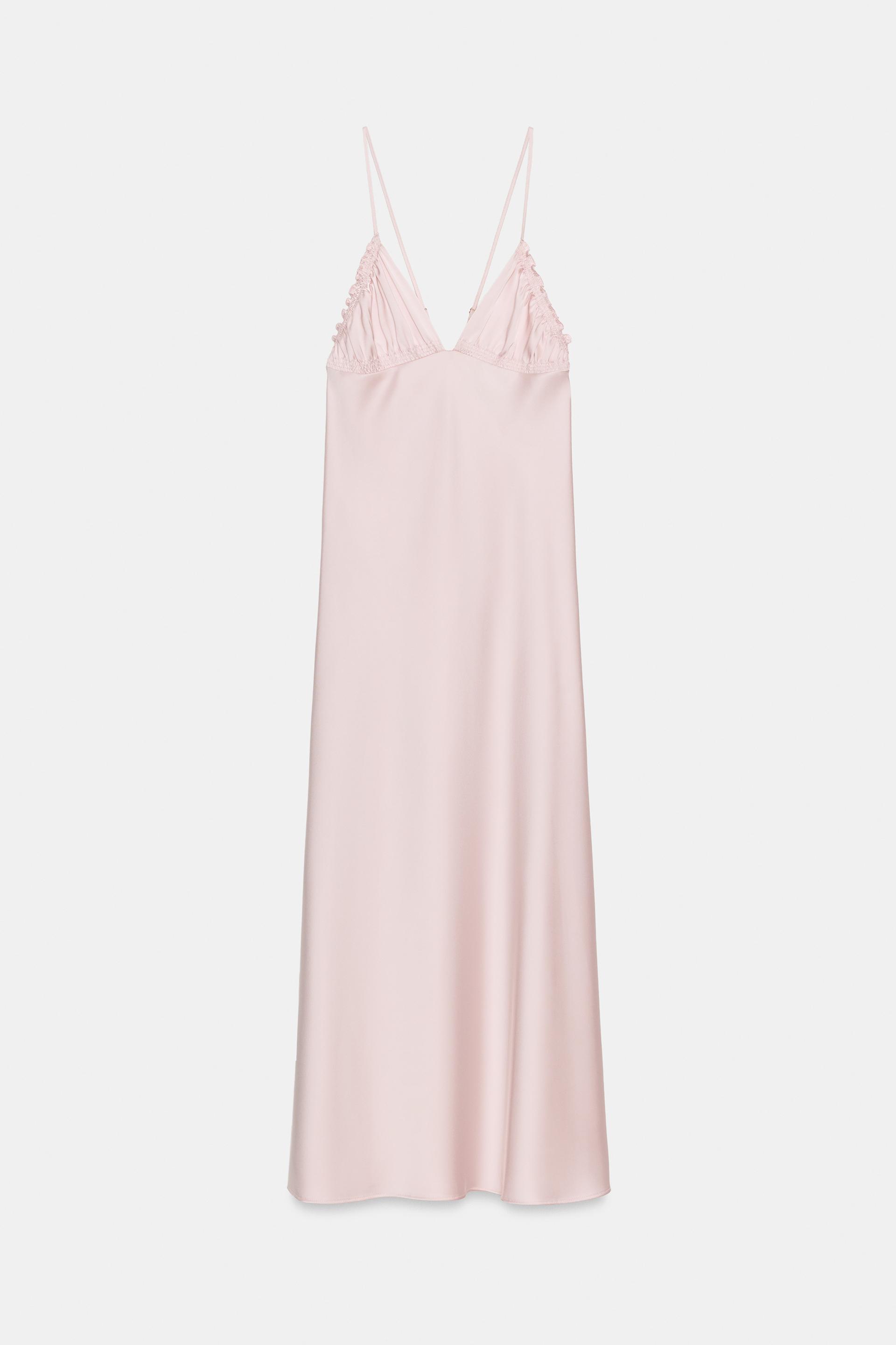 Front view of a light pink dress with thin straps and a ruched V-neck. Knee-length.