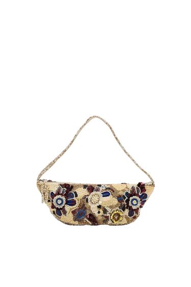 Beige shoulder bag with floral appliqués, beads and sequins in burgundy, blue and yellow tones, with a slender handle on a white background.