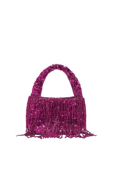 Fuchsia handbag with sequins and fringe, on a white background. Striking and elegant design, ideal for evening events.