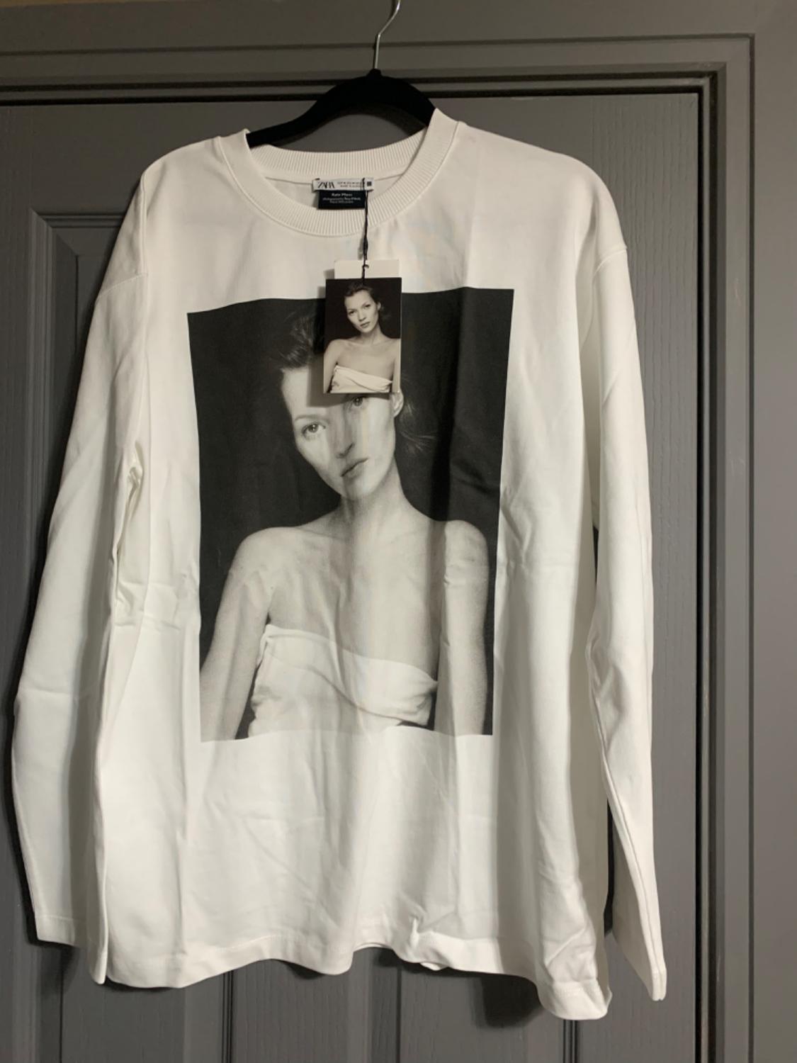 White T-shirt with a black and white photo of a woman on the front. Hang tag with the same image.