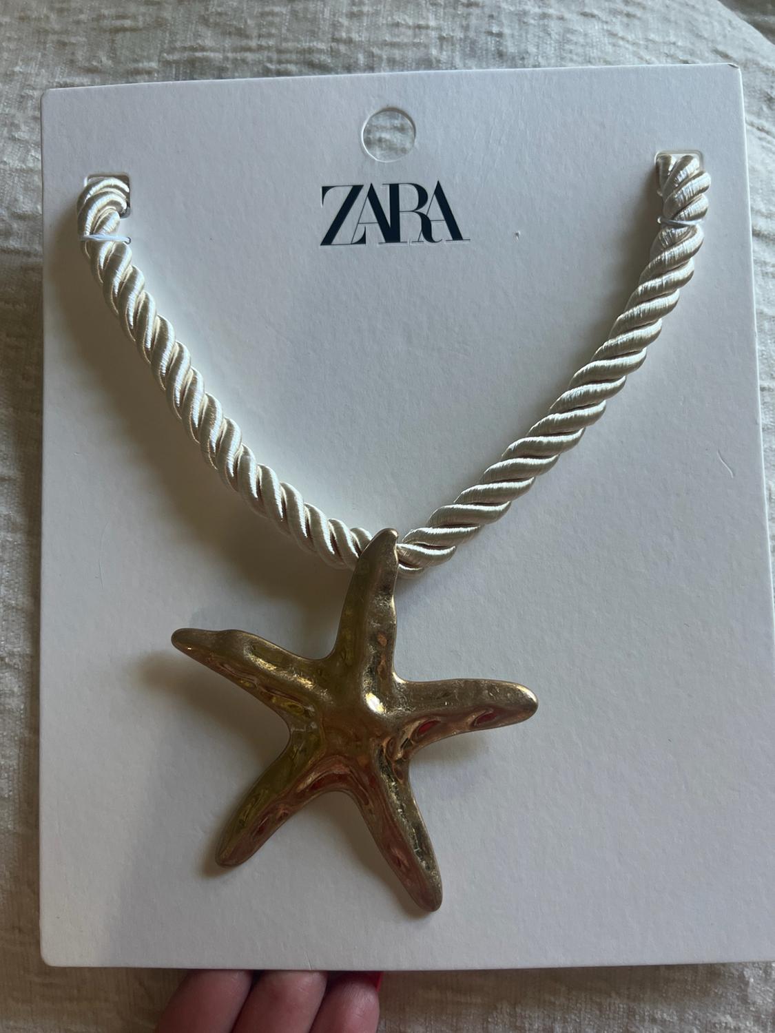 White braided cord necklace with a gold starfish pendant on a card bearing the text ZARA.