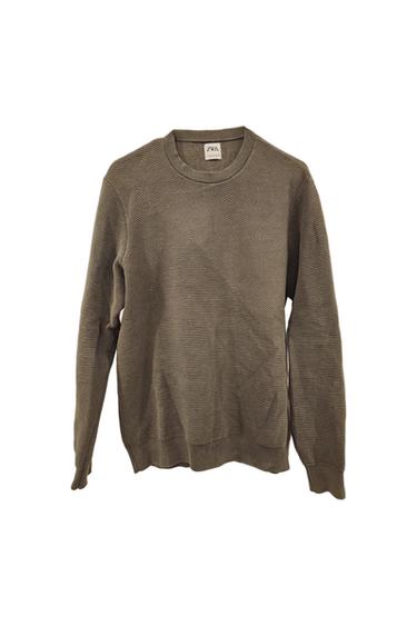 Fine-knit brown sweater with diagonal line texture. Visible tag with the text "ZARA". Long sleeves and round neck.